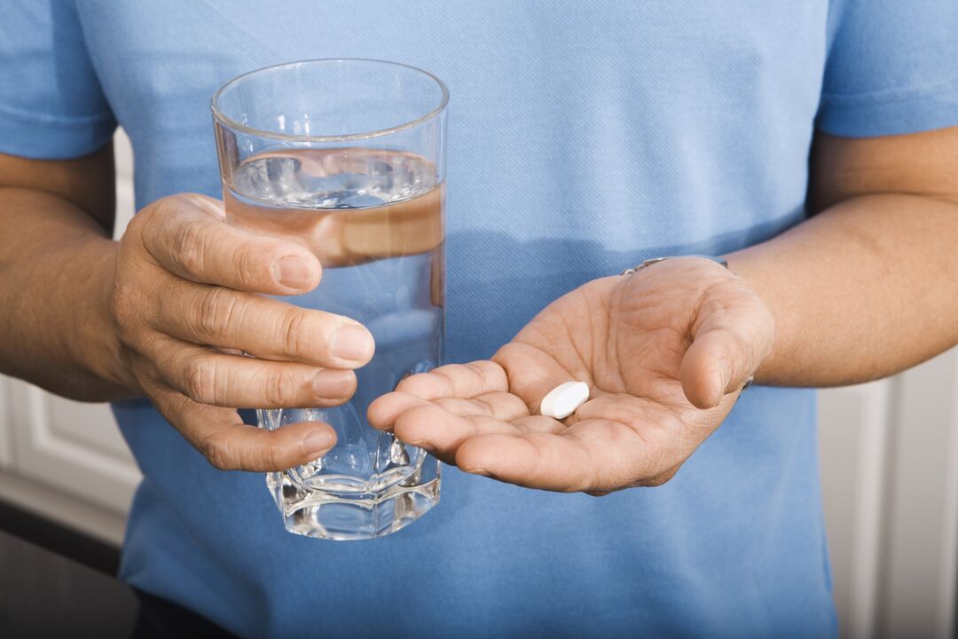muž pije pilulku na parazity